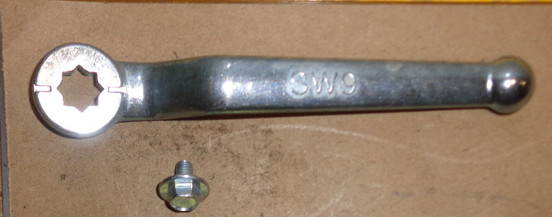 Metal wrench and bolt on a cardboard background