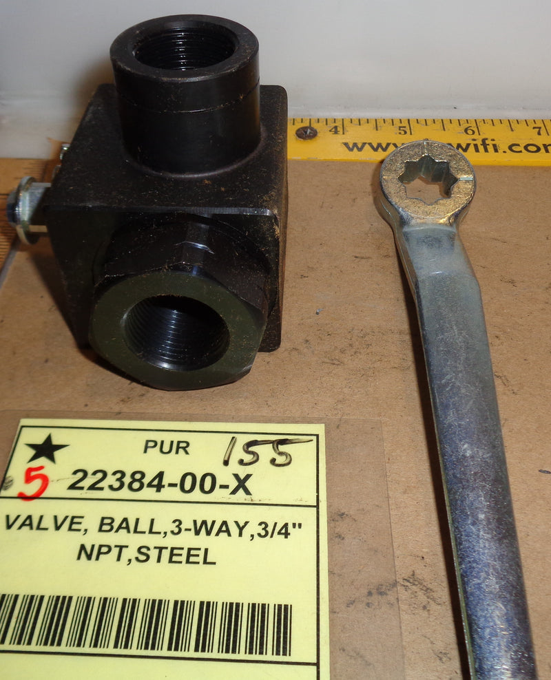 Black ball valve with a wrench and measurement tape on a wooden surface