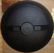 Black round object with a central circular feature on a wooden surface