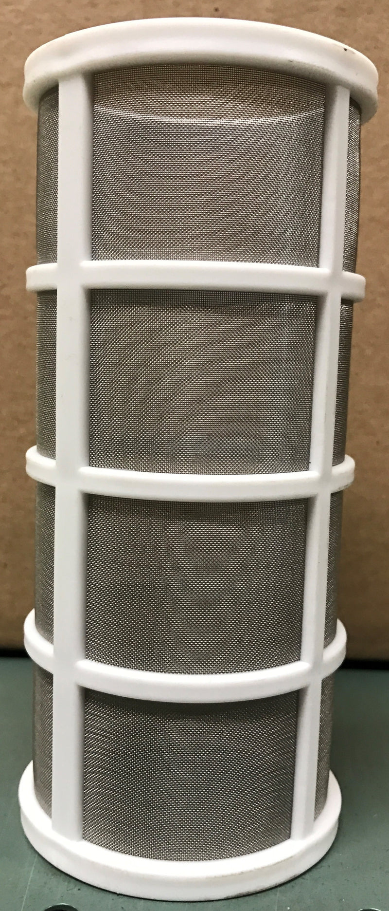 Air filter with white frame and gray pleated media on a green surface.