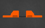 Two orange rectangular objects with a black cable on a dark gray background