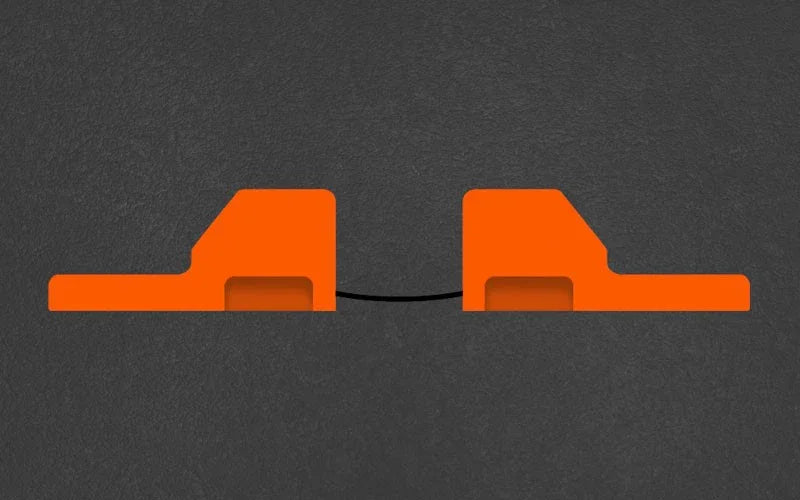 Two orange rectangular objects with a black cable on a dark gray background
